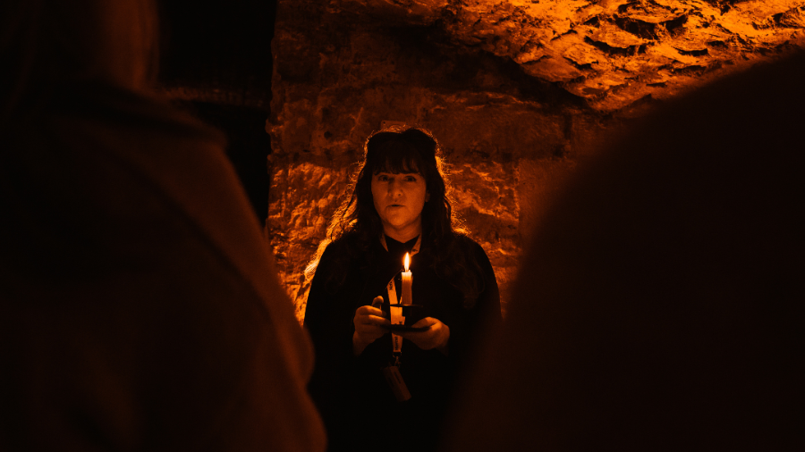 A Mercat Storyteller leading an Edinburgh underground ghost tour in the Edinburgh Vaults.