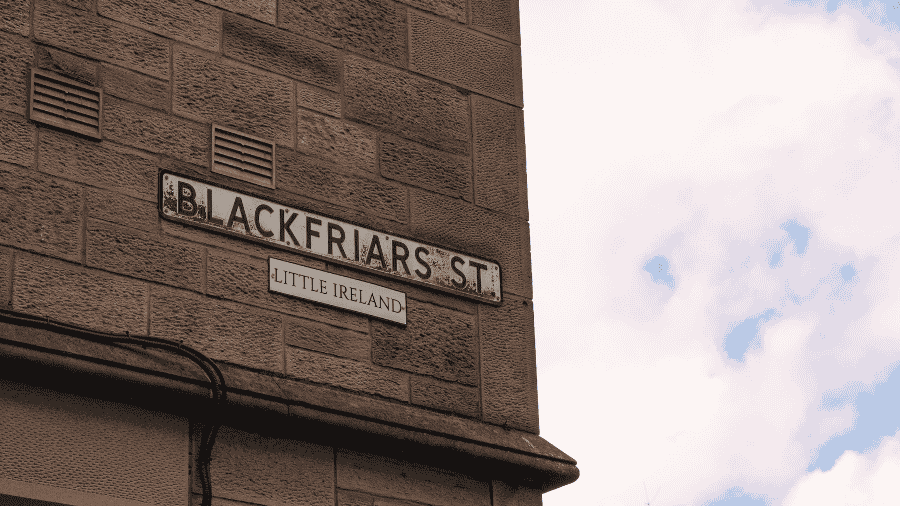 A street sign on a building that reads ‘Blackfriars Street’ and underneath, a smaller signed that reads ‘Little Ireland’.