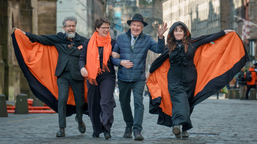 Kat and Des Brogan with two Mercat Storyteller, walking down the Royal Mile in Edinburgh.