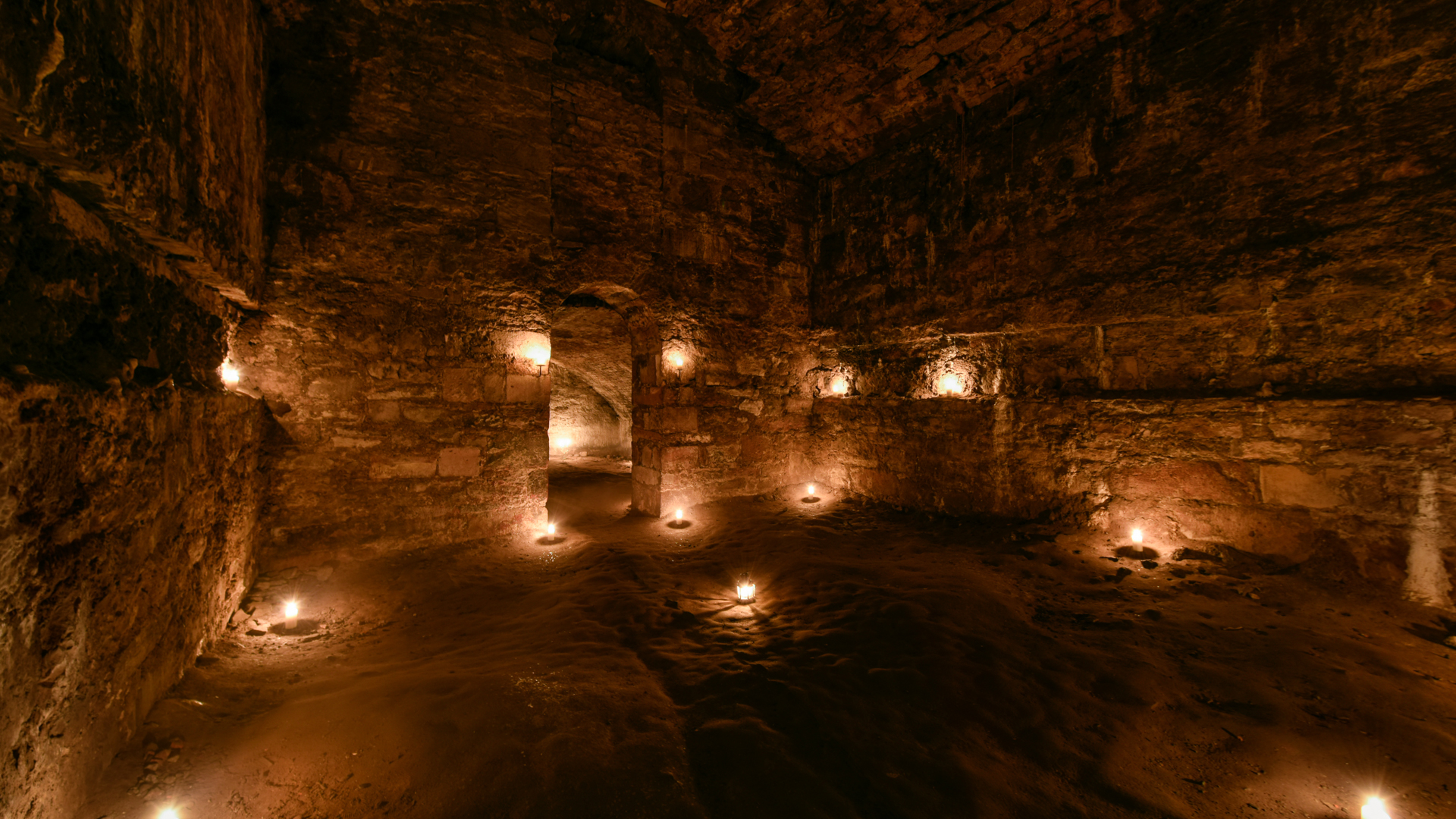 A tall room in the Blair Street Underground Vaults, lit by lots of candles. 